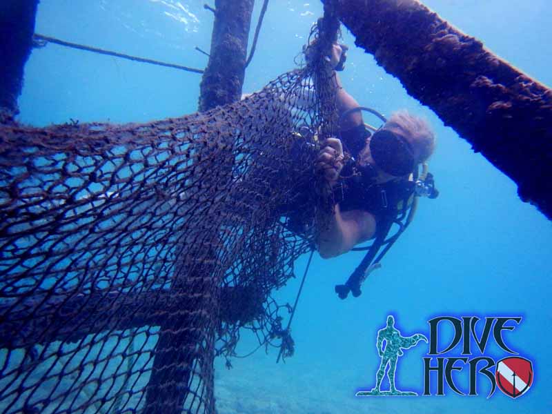 During a Dive Against Debris on Derawan island the dive leader cuts away a ghost net