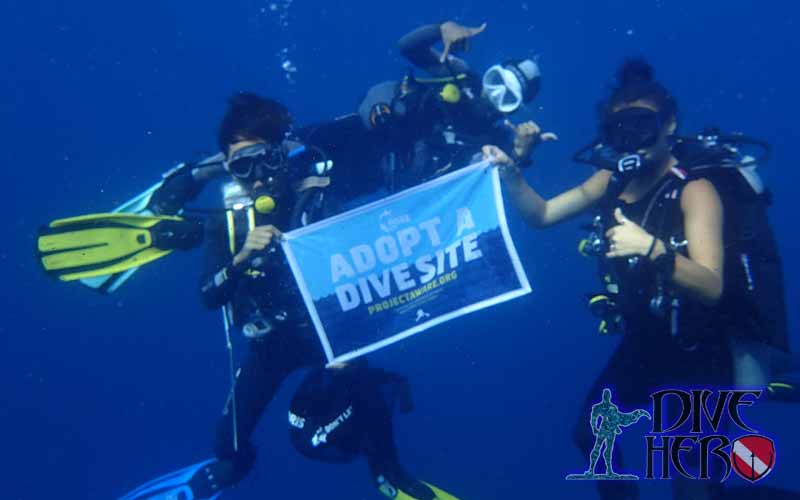 Environmental Activists show their Project Aware Adopt a Dive Site flag during a Dive Against Debris on Bali Indonesia